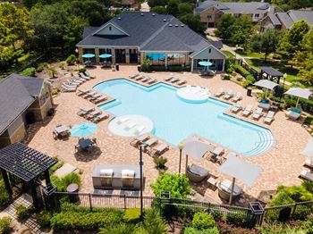 A large swimming pool surrounded by lounge chairs and umbrellas.